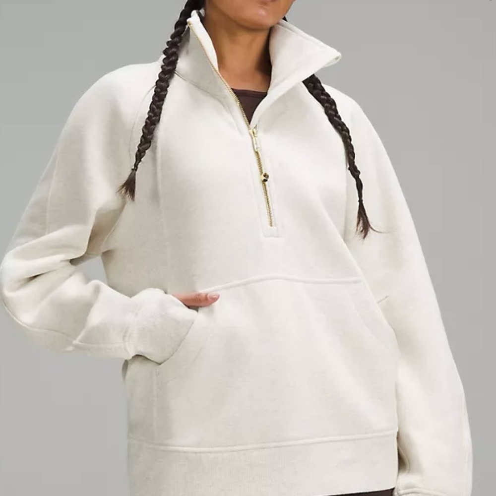 Lululemon NWT, and still in package, cream color with gold half zipper